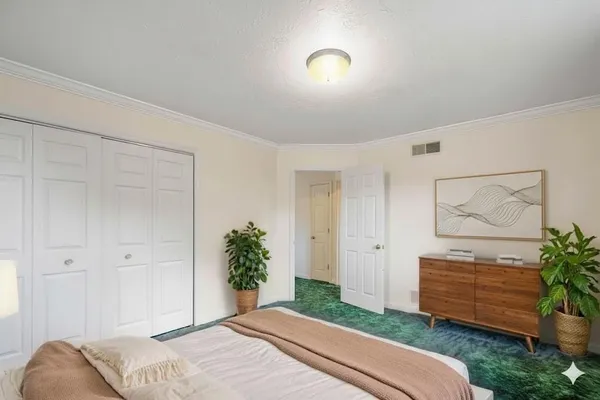 a bedroom with a bed and a potted plant