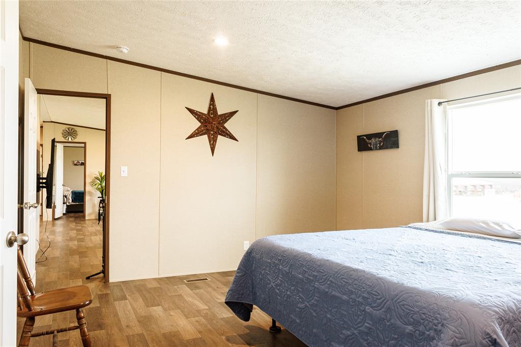103 County Road Comanche, TX 76442 - Photo 29 of 37 a bedroom with a bed and a painting on the wall