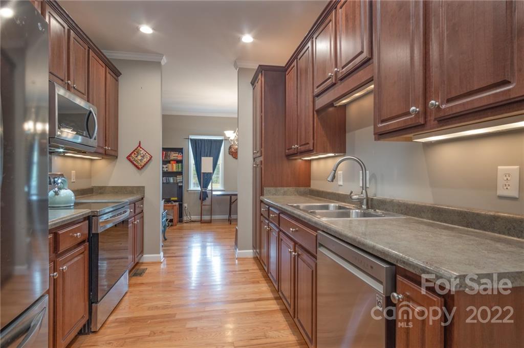6925 Medlin Road Monroe, NC 28112 - Photo 11 of 41 a kitchen with stainless steel appliances granite countertop a sink a stove and a wooden floors