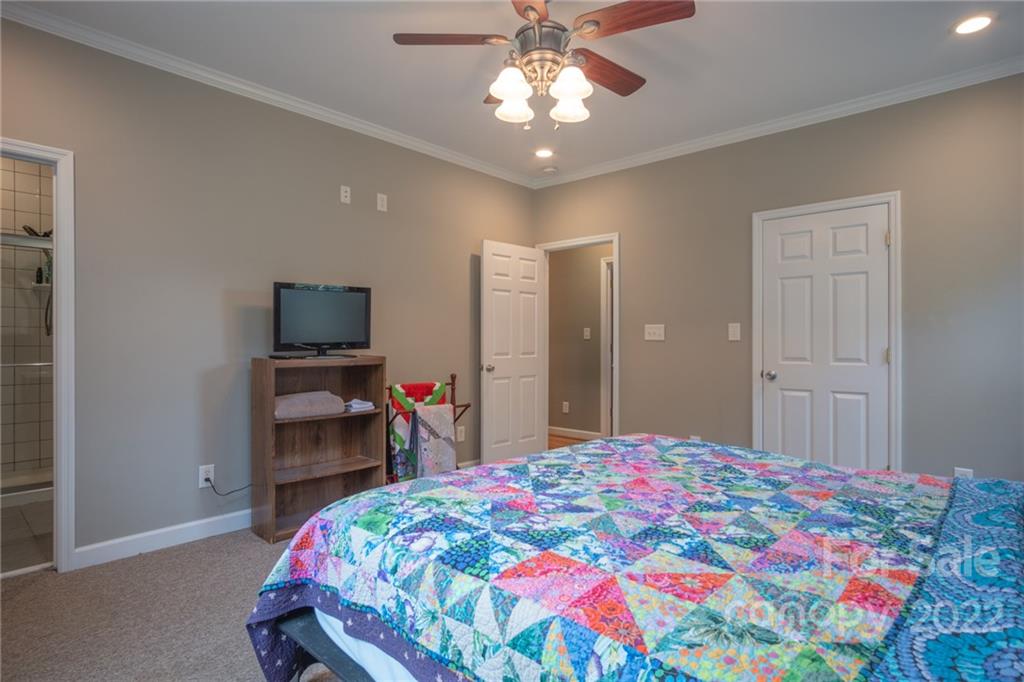 6925 Medlin Road Monroe, NC 28112 - Photo 17 of 41 a bedroom with a bed and a chandelier
