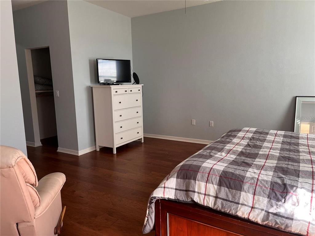 8908 Southwest 84th Circle Ocala, FL 34481 - Photo 11 of 24 a bedroom with a bed and wooden floor