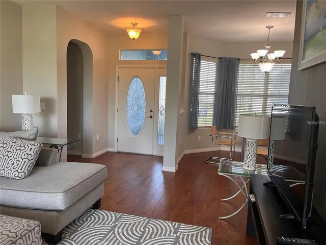 a living room with furniture a fireplace and a chandelier