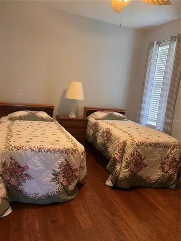 a bedroom with two beds and wooden floor