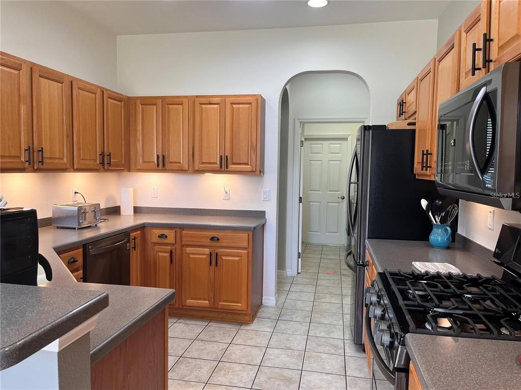 8908 Southwest 84th Circle Ocala, FL 34481 - Photo 6 of 24 a kitchen with stainless steel appliances granite countertop a stove a sink dishwasher and a refrigerator