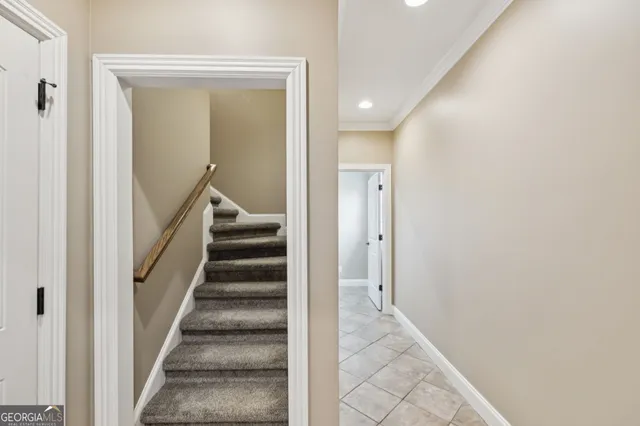 a view of a hallway with staircase and white walls