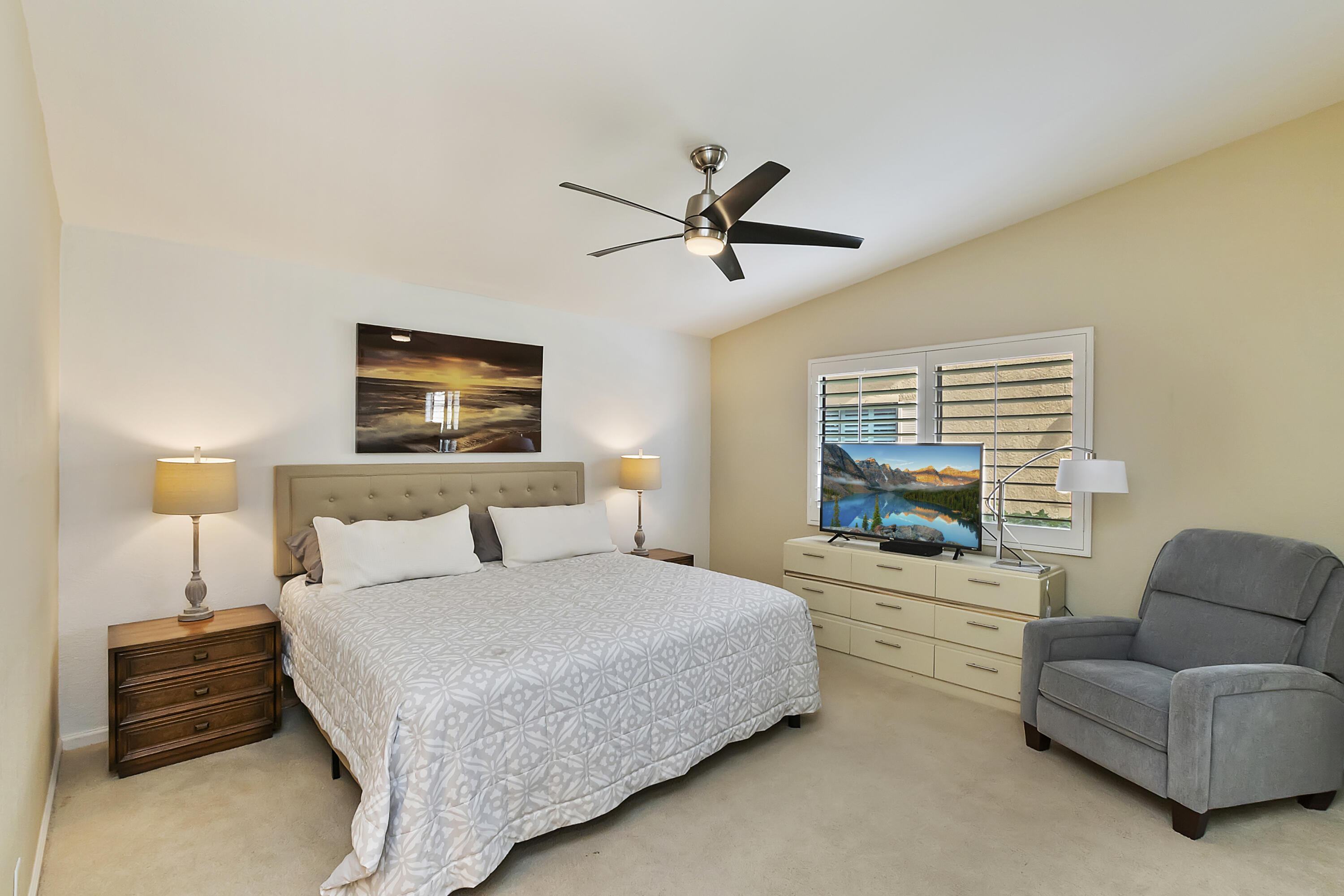 6 Maximo Way Palm Desert, CA 92260 - Photo 13 of 48 a bedroom with a bed a couch and a chandelier