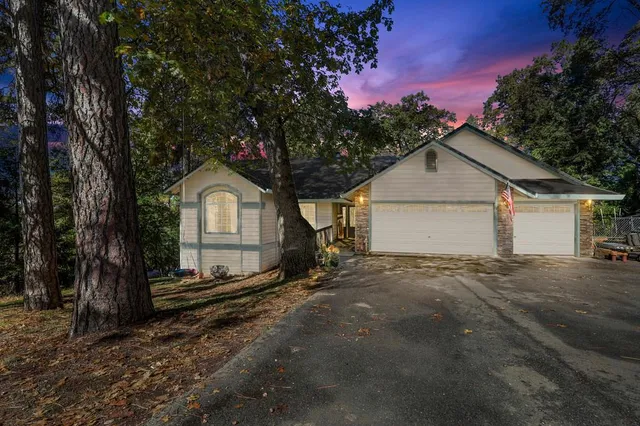 a view of a house with a yard and large tree