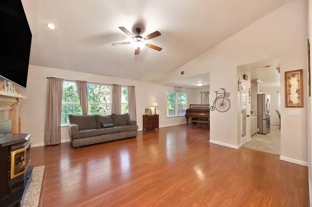 a living room with furniture a wooden floor and a piano