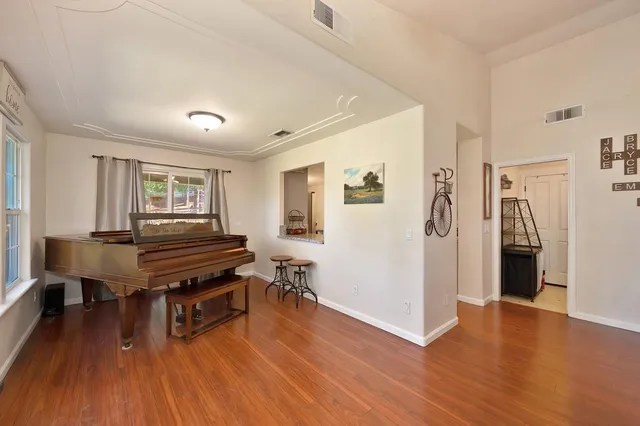 a dining room filled chandelier and wooden floor