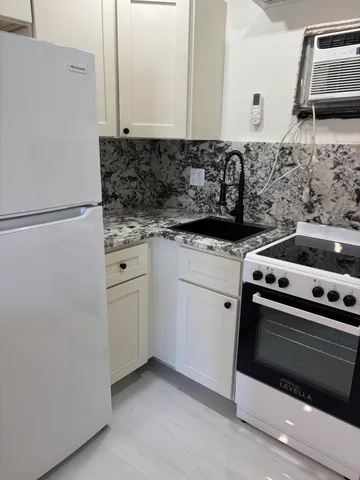 a kitchen with white cabinets and white appliances