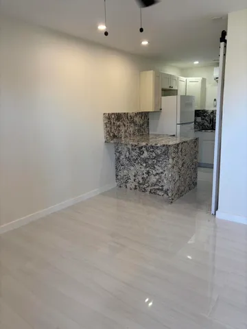 a room with a chandelier and kitchen view