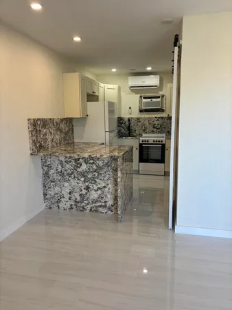 a large kitchen with kitchen island a sink stainless steel appliances and cabinets