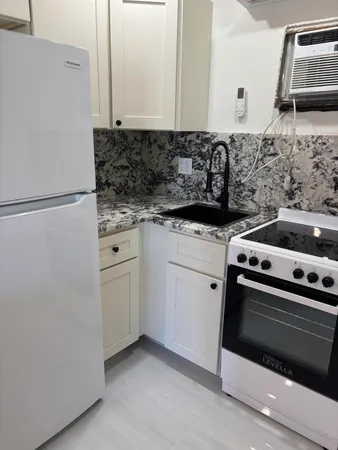 a kitchen with white cabinets and white appliances