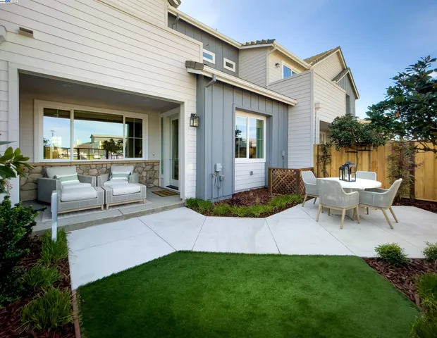 a view of a house with backyard and sitting area