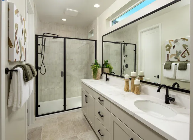 a bathroom with a double vanity sink mirror and shower