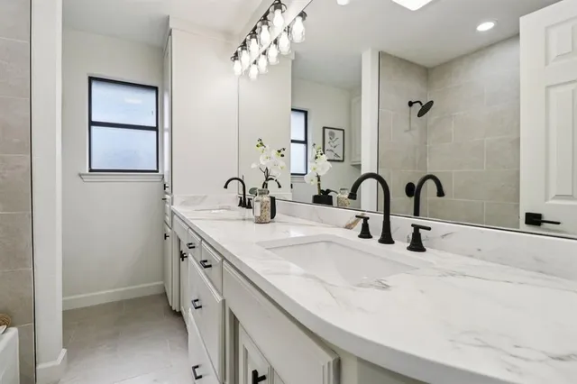 a bathroom with a double vanity sink and a mirror