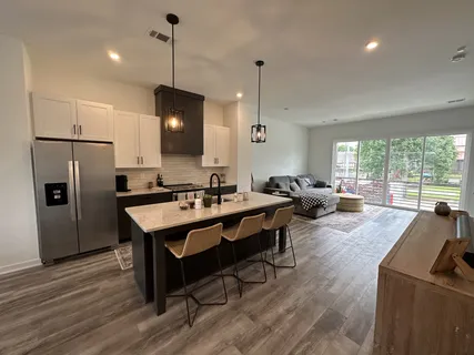 a large kitchen with a table chairs refrigerator and microwave