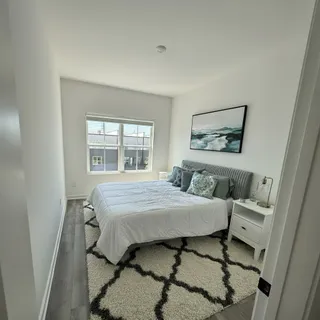 a bedroom with a bed and a large window