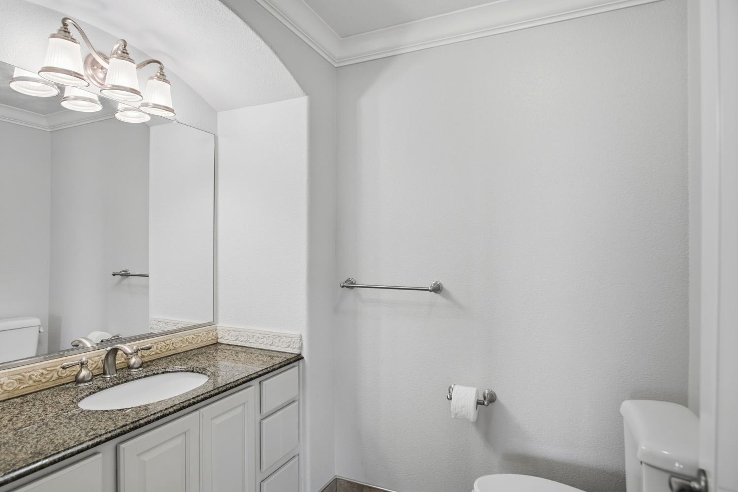 16166 Lawrence Road Escalon, CA 95320 - Photo 20 of 56 a bathroom with a granite countertop sink a toilet and a mirror