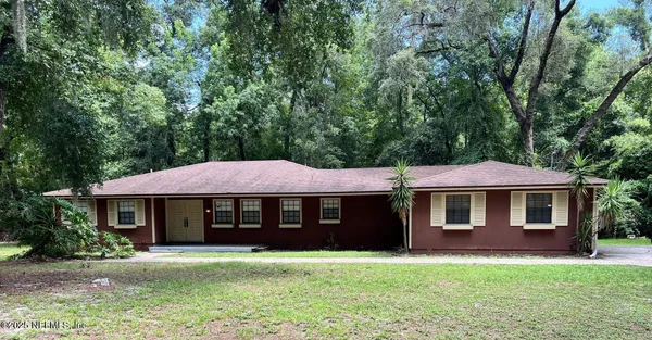 a front view of a house with yard and green space