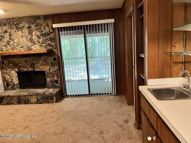 a view of an empty room with cabinet and fan