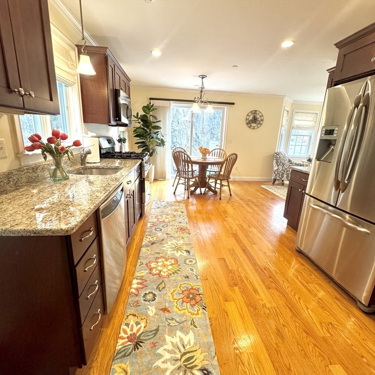 2 B Gates Lane, Unit B Wakefield, MA 01880 - Photo 4 of 42 a kitchen with stainless steel appliances granite countertop table chairs and a refrigerator