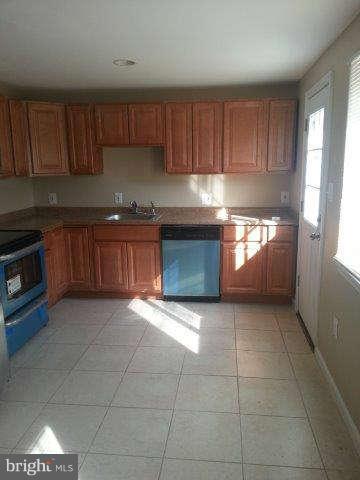 2121 Oak Road Edgemere, MD 21219 - Photo 4 of 8 a kitchen with granite countertop a stove a sink and a microwave