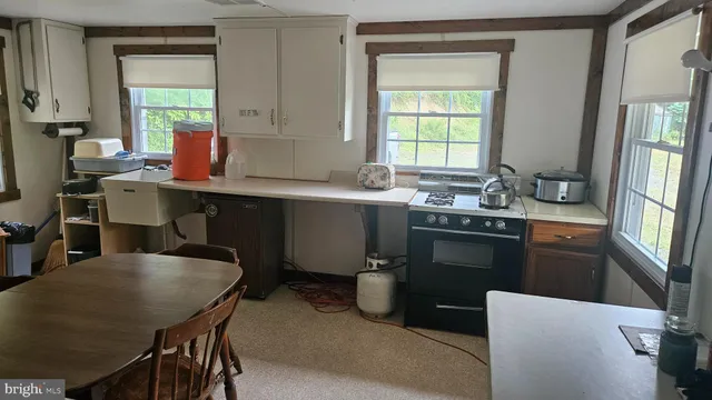a kitchen with a table chairs sink and cabinets