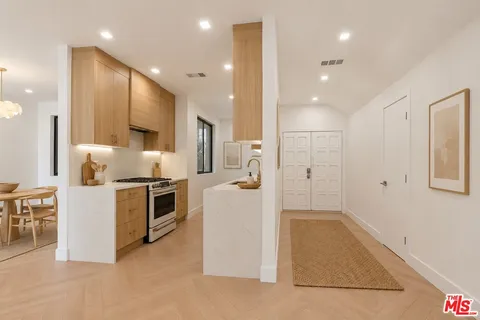 a large white kitchen with a stove a refrigerator and a sink