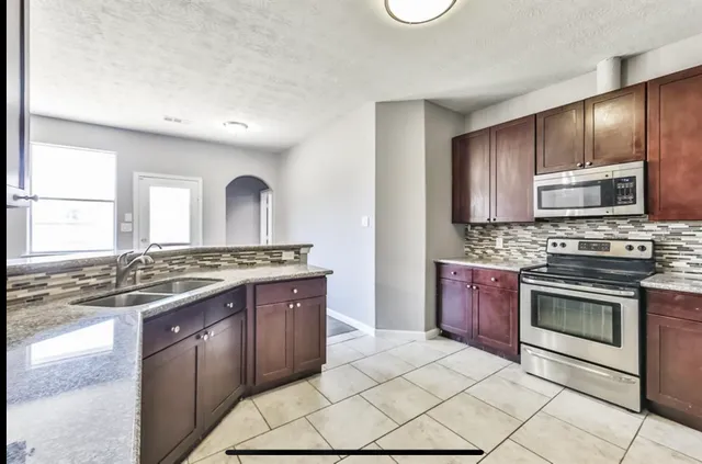 a kitchen with granite countertop a sink and cabinets