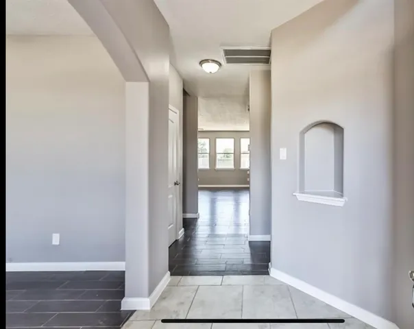 an empty room with wooden floor and a ceiling fan