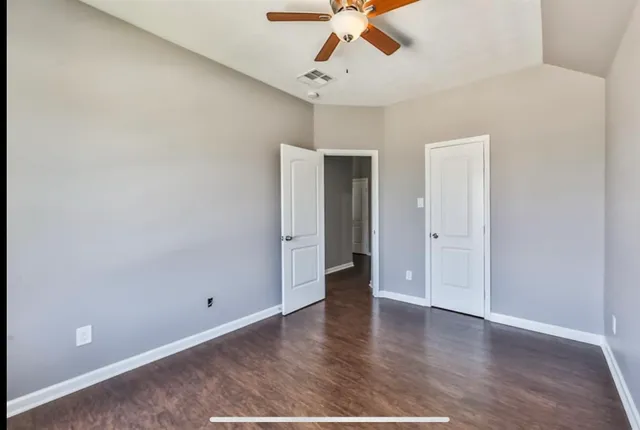 an empty room with a window and a fan
