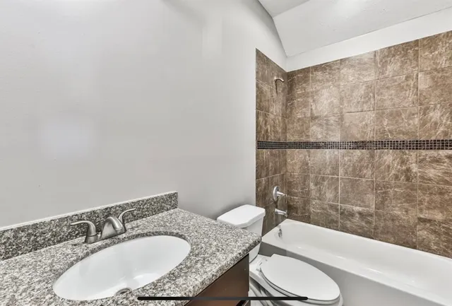 an empty room with wooden floor chandelier fan and windows