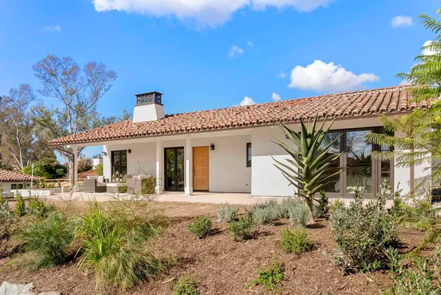 a vase with flowers sitting on a bookshelf next to a yard