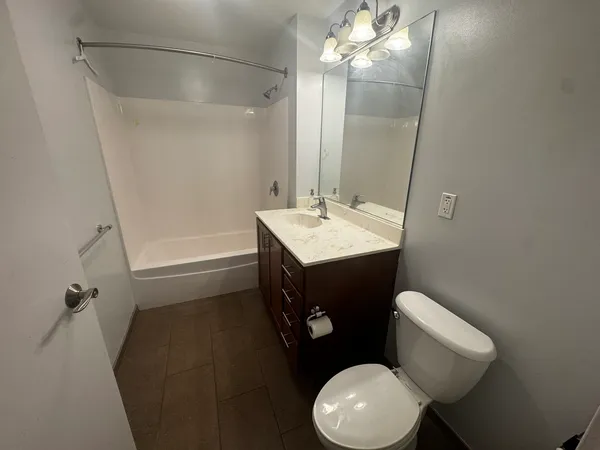 a bathroom with a sink a toilet a mirror and shower