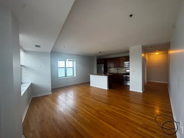 a view of empty room with wooden floor