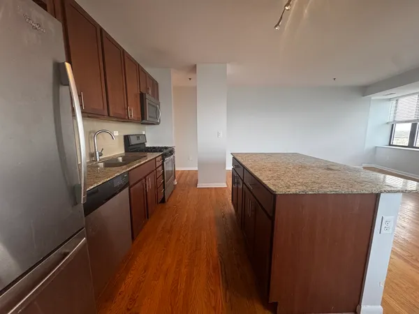 a kitchen with granite countertop a sink stove and refrigerator