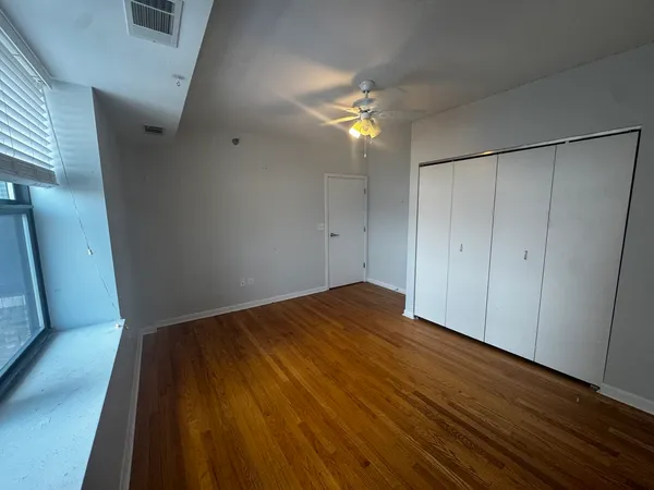 a view of empty room with wooden floor