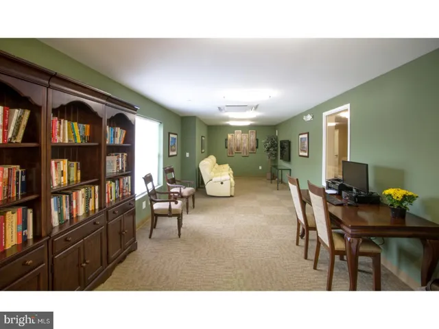 a living room with furniture and a book shelf