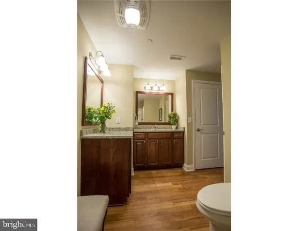 a bathroom with a granite countertop sink mirror vanity and toilet