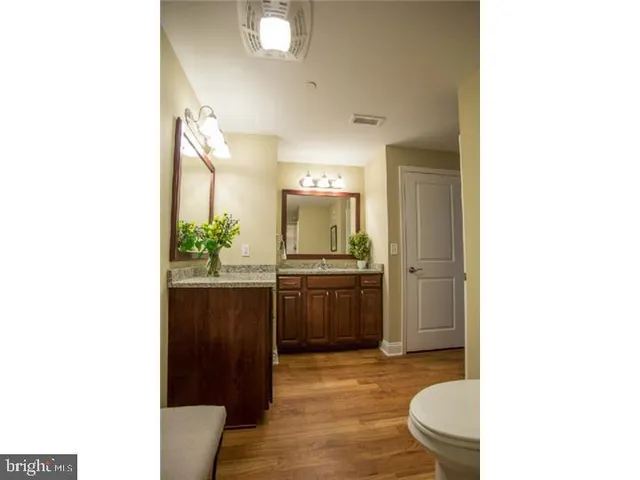 a bathroom with a granite countertop sink mirror vanity and toilet