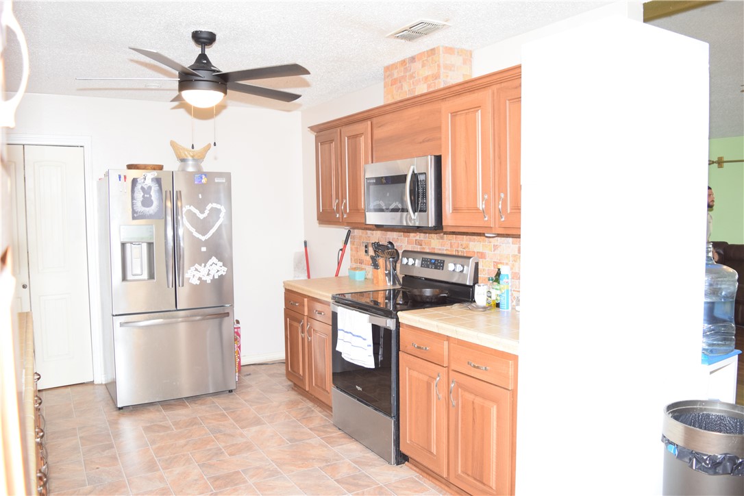 24772 County Road 360 Mathis, TX 78368 - Photo 7 of 30 a kitchen with stainless steel appliances granite countertop a sink stove and refrigerator