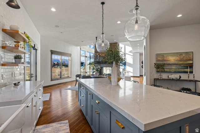 707 Chimney Rock Road, Unit 247 Heber City, UT 84032 - Photo 64 of 64 Kitchen with blue cabinets, open floor plan, light stone countertops, open shelves, and hanging light fixtures