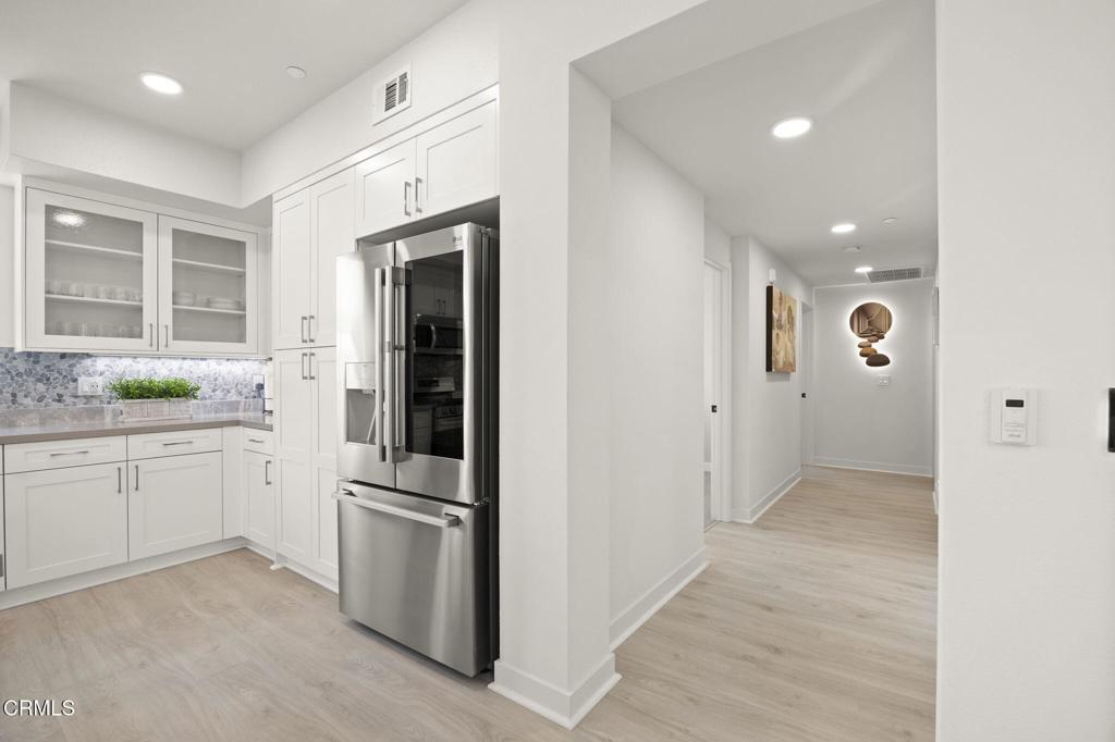 2850 Wagon Wheel Road, Unit 302 Oxnard, CA 93036 - Photo 13 of 50 a kitchen with white cabinets and stainless steel appliances