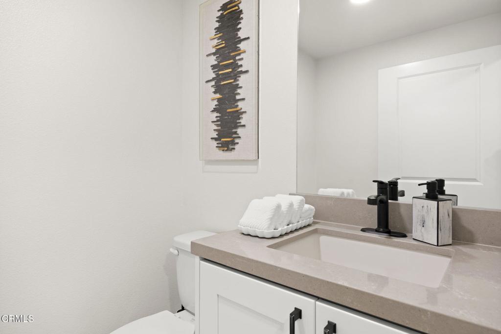 2850 Wagon Wheel Road, Unit 302 Oxnard, CA 93036 - Photo 21 of 50 a bathroom with a granite countertop sink a toilet and mirror