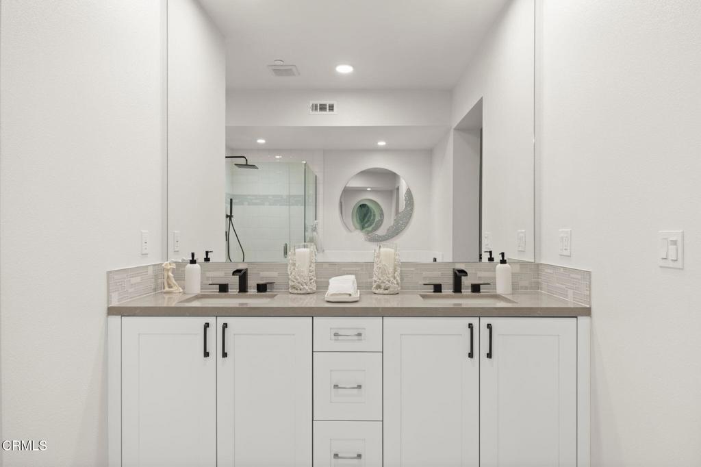 2850 Wagon Wheel Road, Unit 302 Oxnard, CA 93036 - Photo 26 of 50 a bathroom with a double vanity sink and a mirror