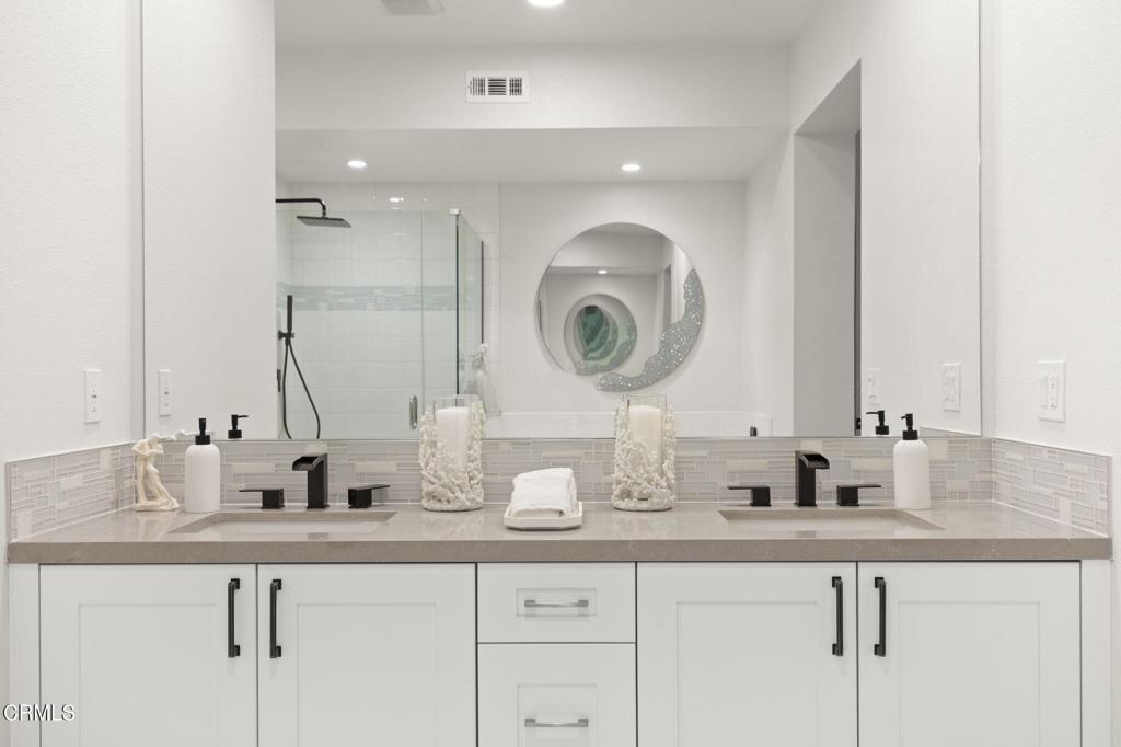 2850 Wagon Wheel Road, Unit 302 Oxnard, CA 93036 - Photo 27 of 50 a bathroom with a double vanity sink and a mirror