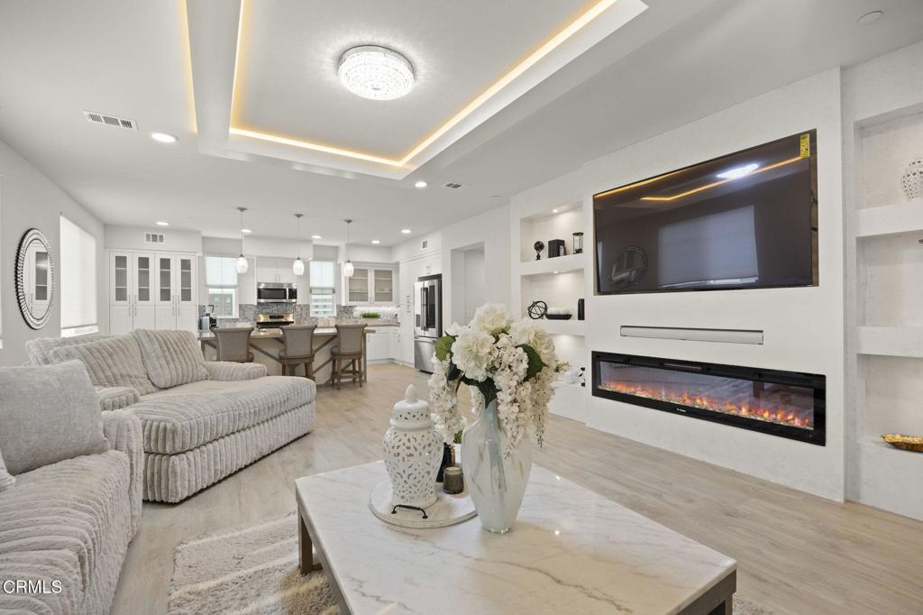 2850 Wagon Wheel Road, Unit 302 Oxnard, CA 93036 - Photo 8 of 50 a living room with furniture a flat screen tv and a fireplace