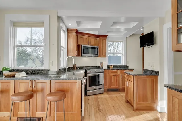 a kitchen with stainless steel appliances granite countertop a stove a sink and a microwave