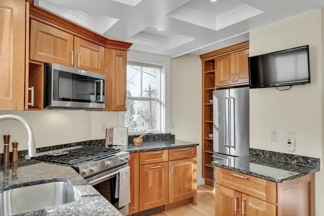 a kitchen with stainless steel appliances granite countertop a stove a sink and a microwave
